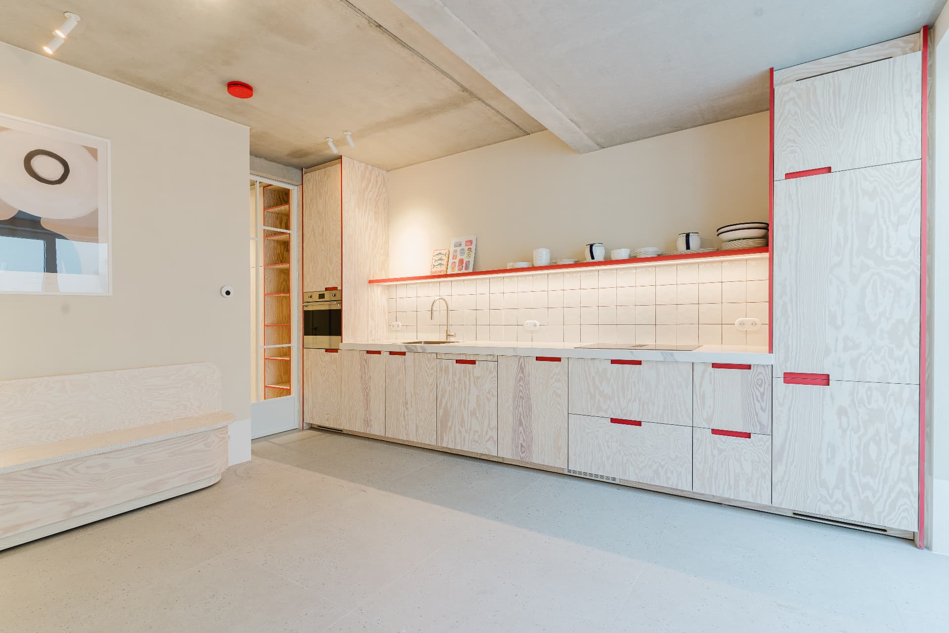 Kitchen with plywood cabinets and red handles